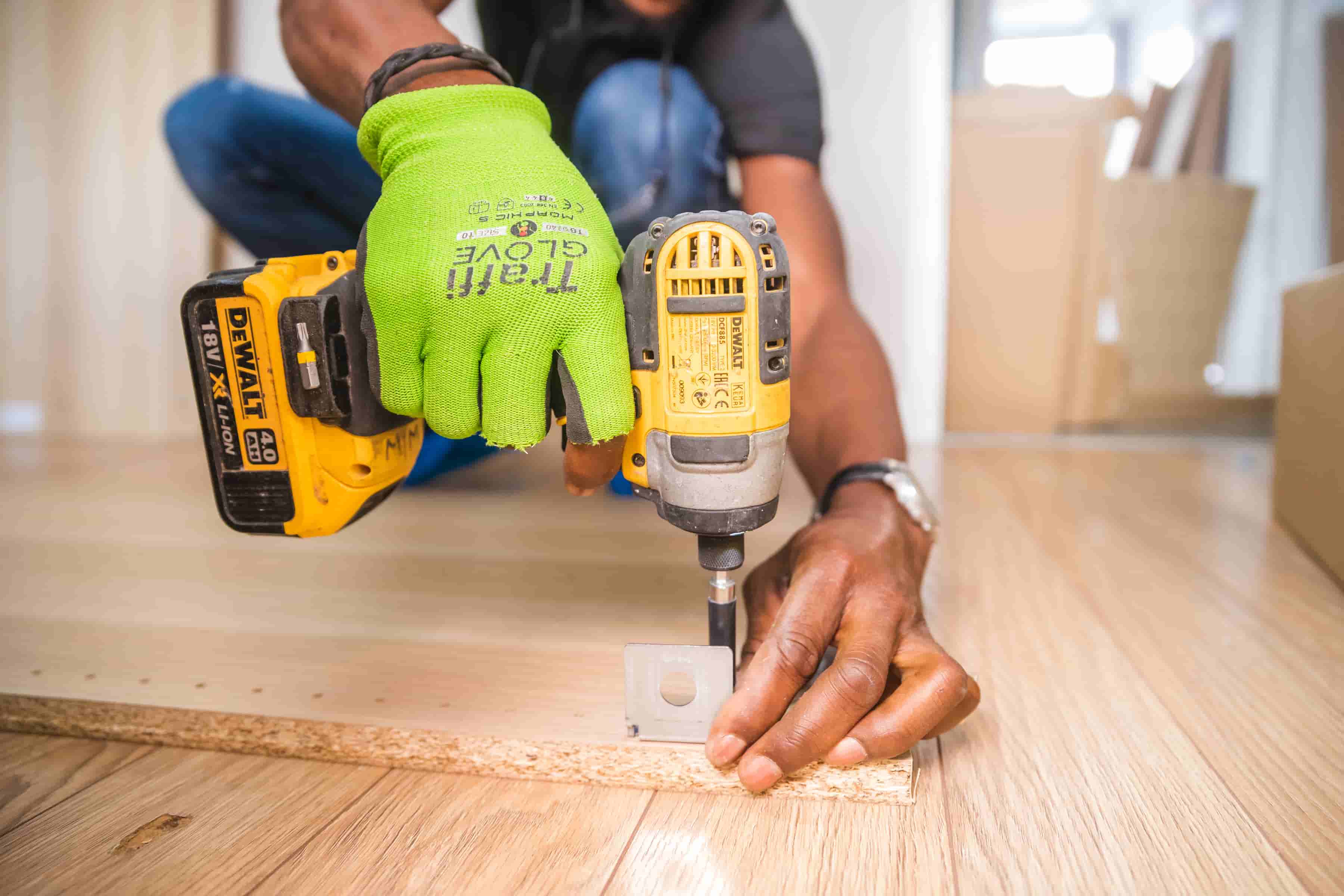 Handyman doing household jobs using drill and flooring